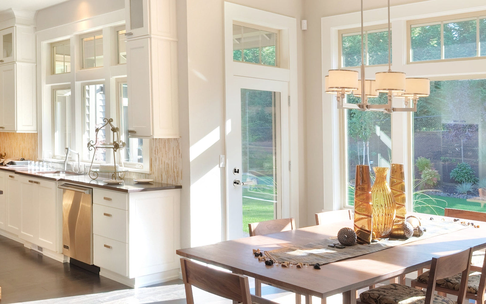 elevated sunny kitchen and dining area with full wall windows looking into back yard